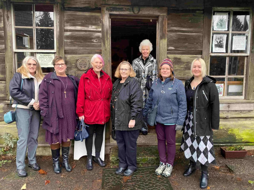 Members on a trip to a local museum, posing in front of the museum for a picture.